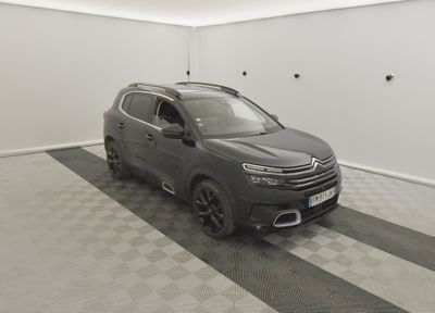 un SUV gris garé dans un garage au sol carrelé