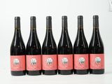 six bouteilles de vin sont alignées sur une surface blanche
