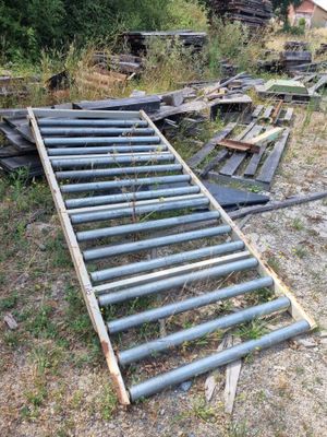 un tas de vieux tuyaux métalliques posés dans l'herbe