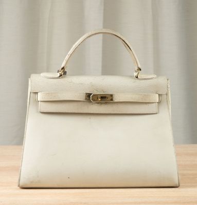 a white handbag sitting on top of a wooden table