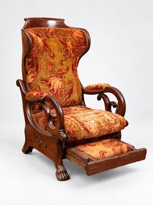 une image représentant une chaise dont l'assise et le repose-pieds sont recouverts d'un tissu à motifs floraux