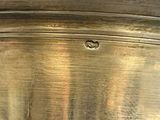 a large metal pot with a handle on a table