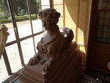une statue représentant une femme assise sur un rebord de fenêtre