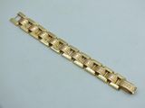 a close up of a gold bracelet on a white surface