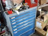 a blue workbench in a garage with a lot of tools on it