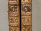 paire de livres anciens reliés en cuir, ornés de motifs dorés et noirs