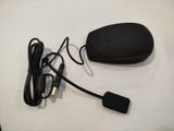 a black mouse and a black cord on a white surface
