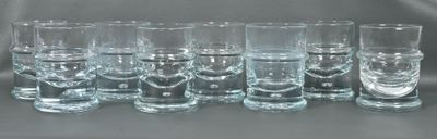 six shot glasses lined up in a row on a table
