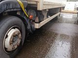 two large trucks parked next to each other on a wet street