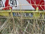 a red and white sign on the back of a yellow car