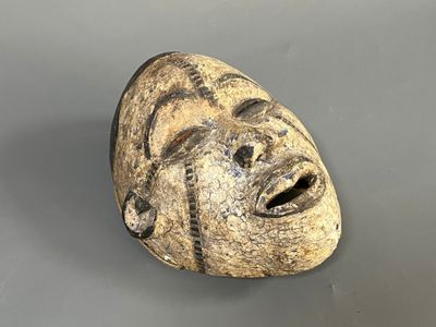 une image représentant un masque en pierre sur une surface grise
