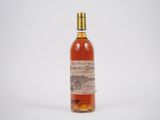 une vieille bouteille de whisky posée sur une surface blanche