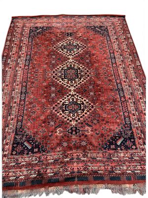 un tapis persan ancien aux motifs rouges et noirs