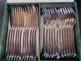 a lot of silverware in a box on the table