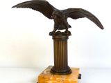 statue d'un aigle sur un socle, sur fond blanc