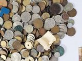 a pile of coins on a table next to a calculator