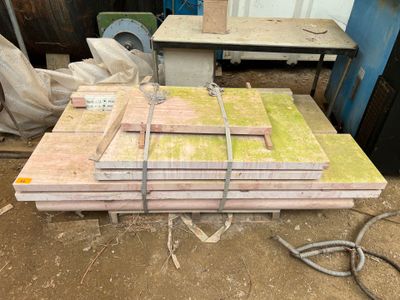 Dans un atelier, plusieurs morceaux de bois sont empilés les uns sur les autres