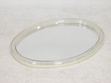 un petit miroir ovale posé sur une table, sur fond blanc