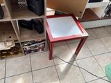a small table with a glass top on a tiled floor
