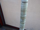 a tall wooden pole with a marble top on the ground