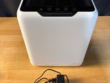 an air purifier sitting on top of a wooden table next to a charger