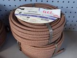 plusieurs rouleaux de corde posés sur une étagère dans un magasin