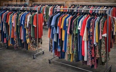 a lot of clothes hanging on a rack in a room