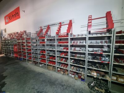 de nombreuses étagères remplies d'outils dans un magasin où est accrochée une enseigne rouge au mur