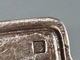 a close up of a silver plate with a bird on it