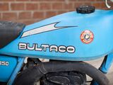 a blue motorcycle parked in front of a brick wall