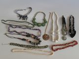 tout un tas de colliers et de bracelets différents posés sur la table