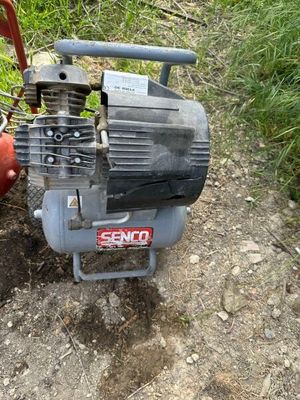 un petit compresseur d'air posé par terre à côté d'une borne d'incendie