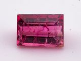 a pink tourmaline stone on a white surface