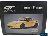 the box of a yellow sports car is sitting on a white surface