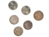 six pièces différentes sont disposées en cercle sur une surface blanche