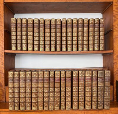 une vieille bibliothèque remplie de nombreux livres posés sur des étagères en bois