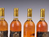 four bottles of wine are lined up in a row