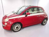 a small red and white car parked in a white room