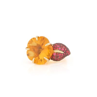 un gros plan d'une bague sertie d'une topaze jaune et de saphirs roses