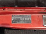 a close up of a red car with a metal plate on it