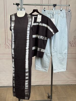 a black and white dress on a stand next to a pair of jeans