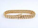 a close up of a gold bracelet on a white background