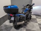 a blue motorcycle parked in a room with a checkered floor