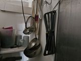 a black refrigerator in a kitchen with a fan on the wall