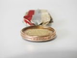 a small coin sitting on a table next to a small piece of paper