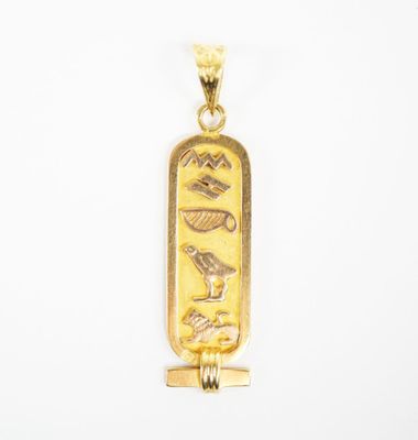 a close up of a gold pendant on a white background