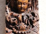 carved wood carving of a man with a bird on his head