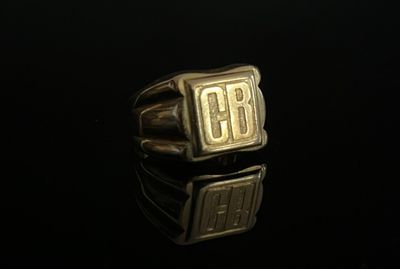 un gros plan d'une bague en or sur laquelle est gravé « cb »