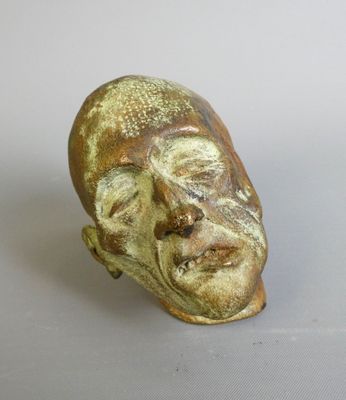 a ceramic sculpture of a man ' s face on a table