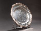 a silver plate that is on a stand on a table